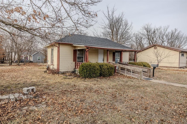 view of front of house featuring fence, a porch, and roof with shingles