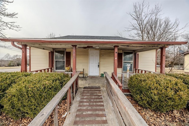 bungalow-style home featuring a porch and roof with shingles