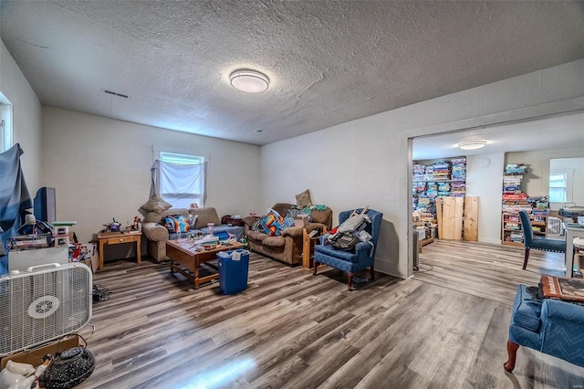 playroom with a textured ceiling, visible vents, and wood finished floors