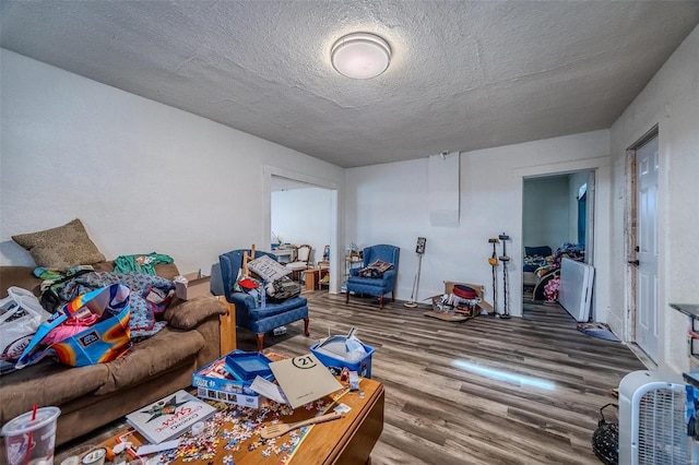 living area with a textured ceiling and wood finished floors