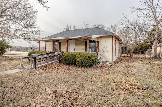 bungalow-style home with a porch and roof with shingles