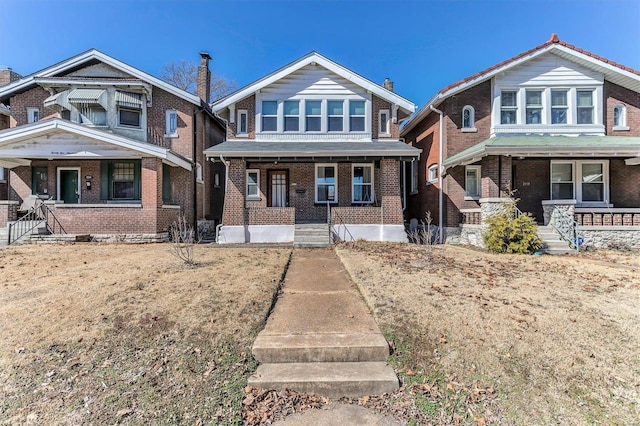 view of front of property featuring brick siding and covered porch