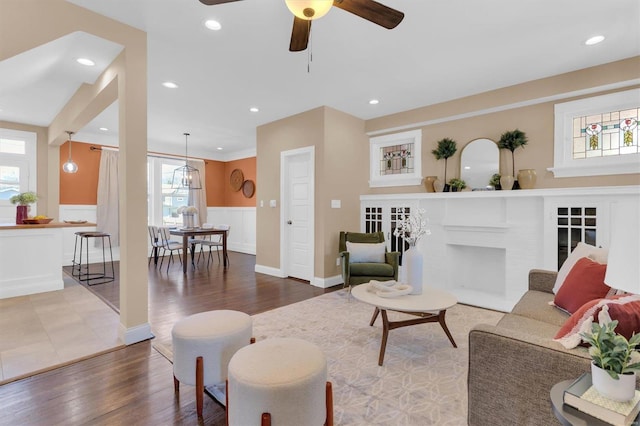 living area featuring a brick fireplace, recessed lighting, wood finished floors, and ceiling fan