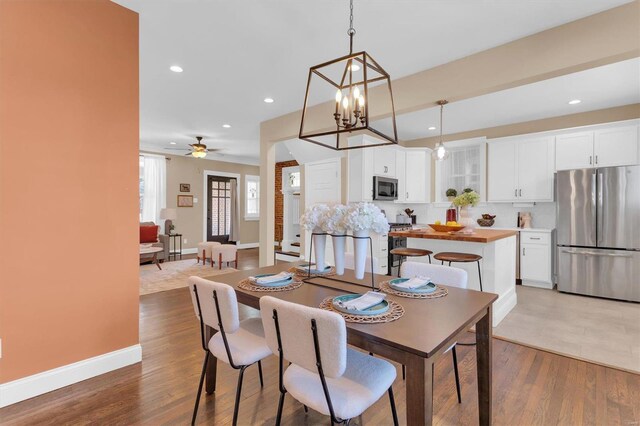 dining space featuring recessed lighting, baseboards, and wood finished floors