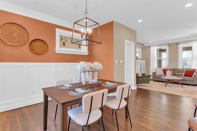 dining space with a decorative wall, recessed lighting, wood finished floors, and wainscoting