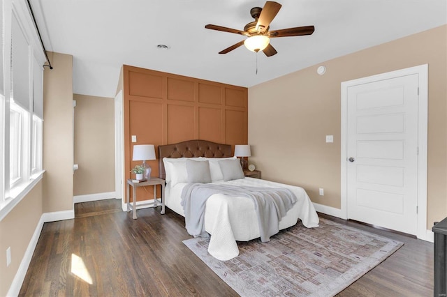 bedroom with baseboards, dark wood finished floors, and a ceiling fan