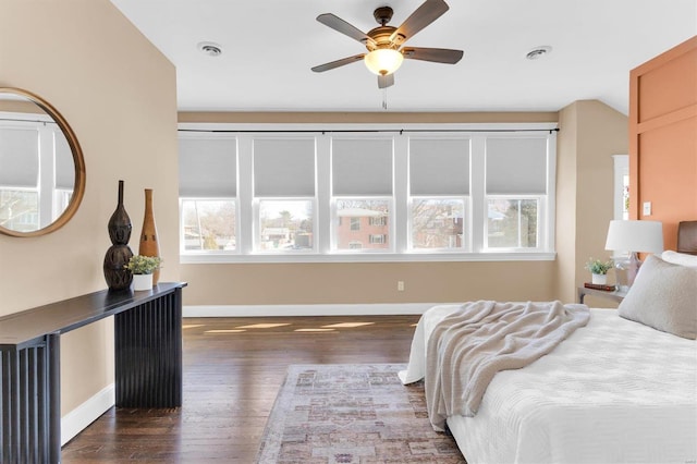 bedroom featuring dark wood-type flooring, multiple windows, baseboards, and visible vents