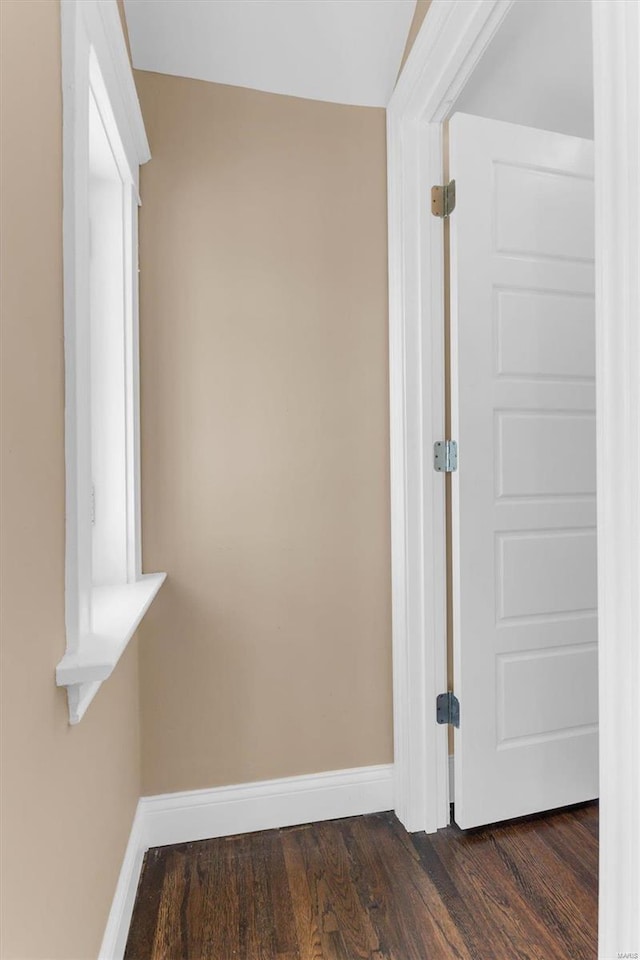 interior space with dark wood-type flooring and baseboards