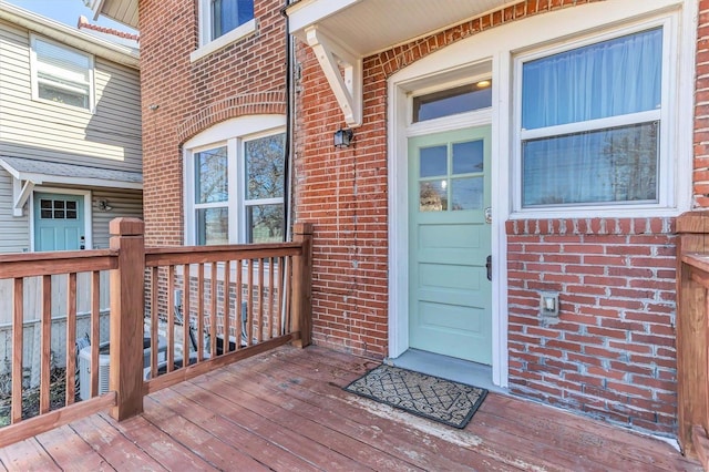 doorway to property featuring a garage and brick siding