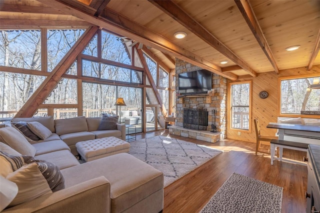 living area featuring wooden ceiling, a fireplace, wood finished floors, and beamed ceiling