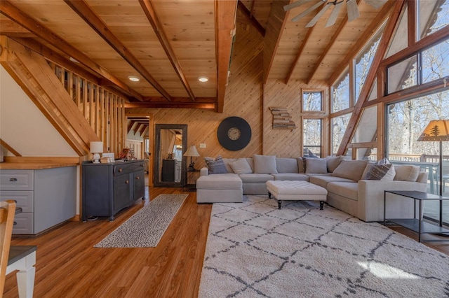 living room featuring light wood-style floors, beam ceiling, wooden ceiling, and plenty of natural light