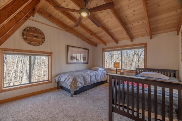 carpeted bedroom featuring lofted ceiling with beams, wooden ceiling, and baseboards