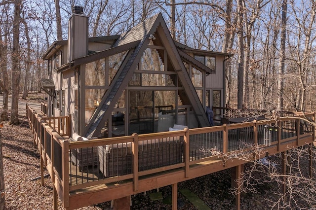 back of property featuring a chimney and a wooden deck