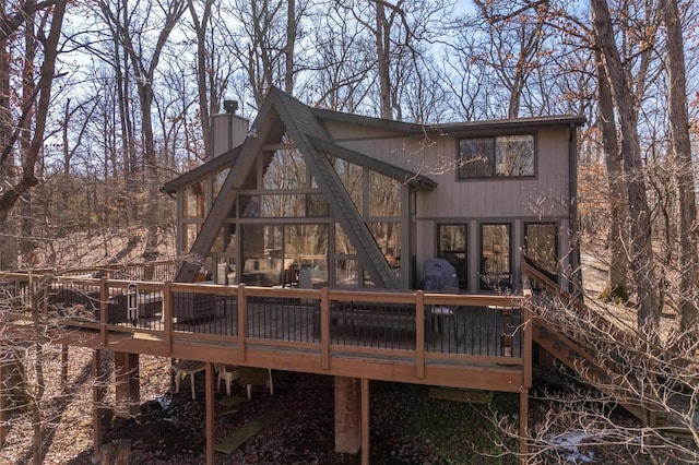 back of property featuring stairway, a chimney, and a wooden deck