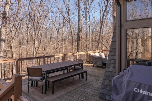 wooden deck with outdoor dining area and grilling area