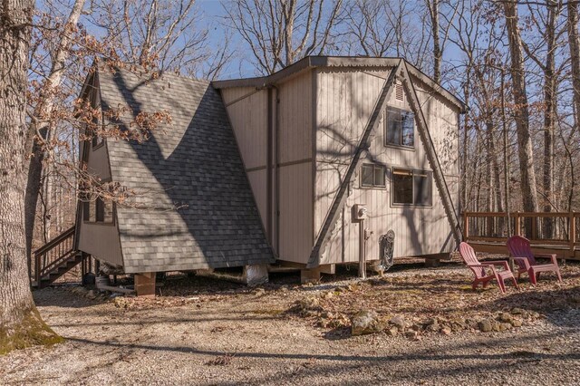 view of side of home featuring roof with shingles