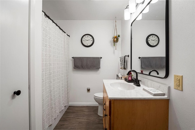 full bath with baseboards, vanity, toilet, and wood finished floors