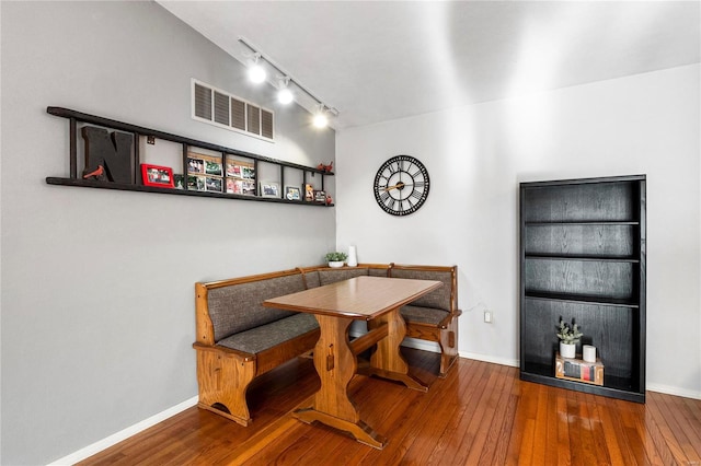 dining room featuring breakfast area, visible vents, baseboards, and hardwood / wood-style flooring