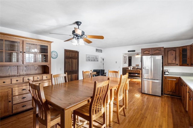 dining space featuring hardwood / wood-style flooring, visible vents, and a ceiling fan