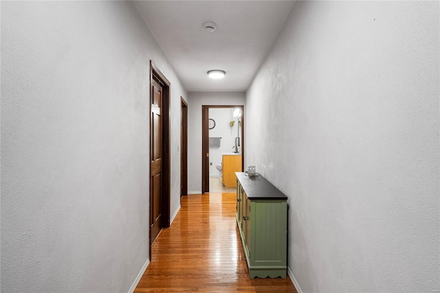 corridor with wood finished floors and baseboards