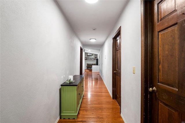 hall featuring baseboards and wood finished floors