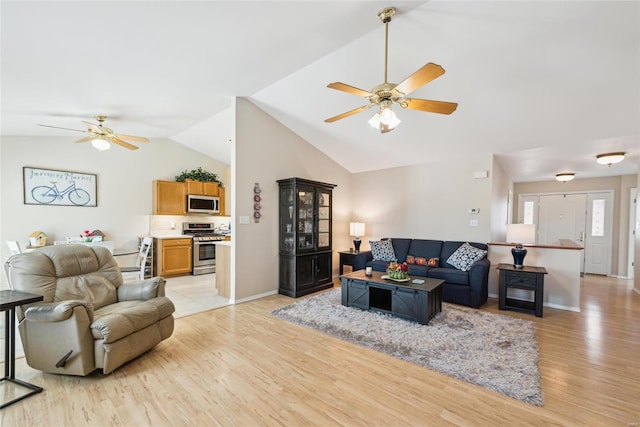 living room featuring lofted ceiling, light wood-style flooring, baseboards, and ceiling fan