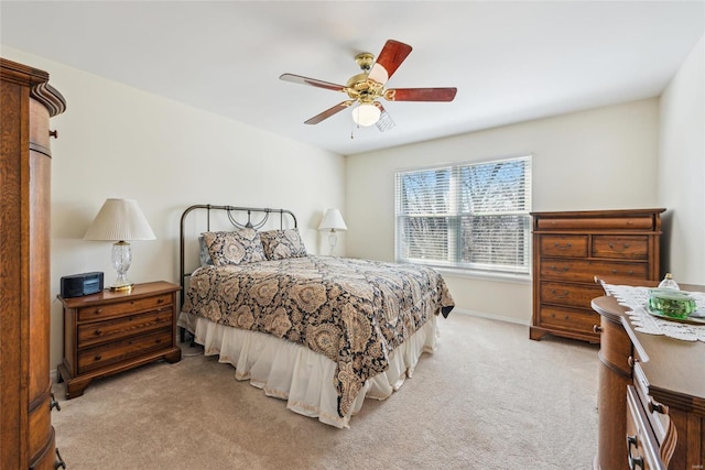 bedroom with light carpet, ceiling fan, and baseboards