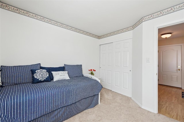 bedroom with carpet floors, baseboards, and a closet