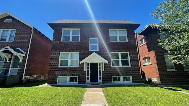 view of front of property featuring brick siding and a front lawn