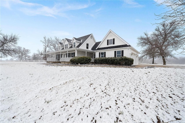 view of front of home with fence, an attached garage, and a sunroom