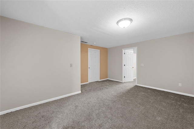 spare room featuring visible vents, baseboards, a textured ceiling, and carpet flooring