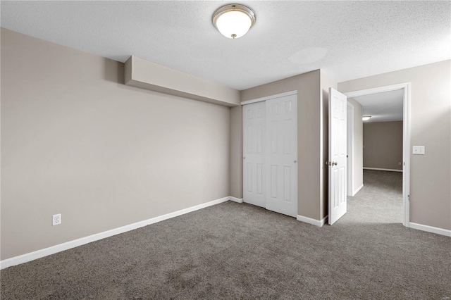 unfurnished bedroom featuring baseboards, carpet floors, a textured ceiling, and a closet