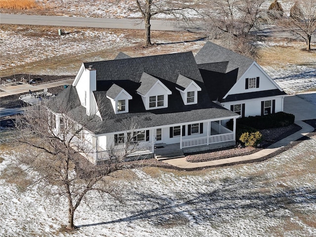 view of front facade featuring covered porch and a shingled roof