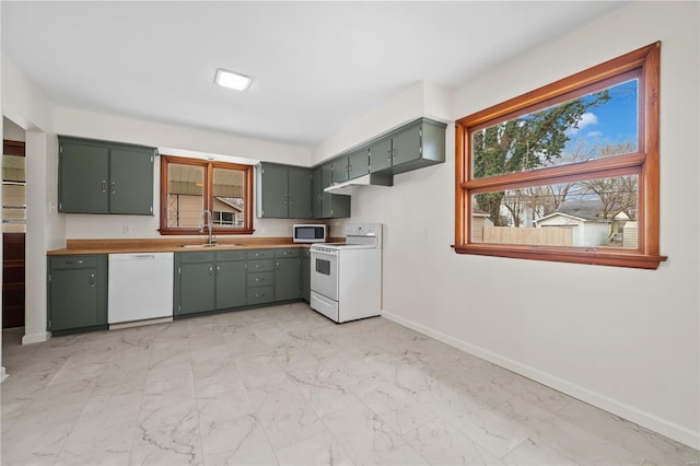 kitchen featuring white appliances, marble finish floor, green cabinets, and a sink