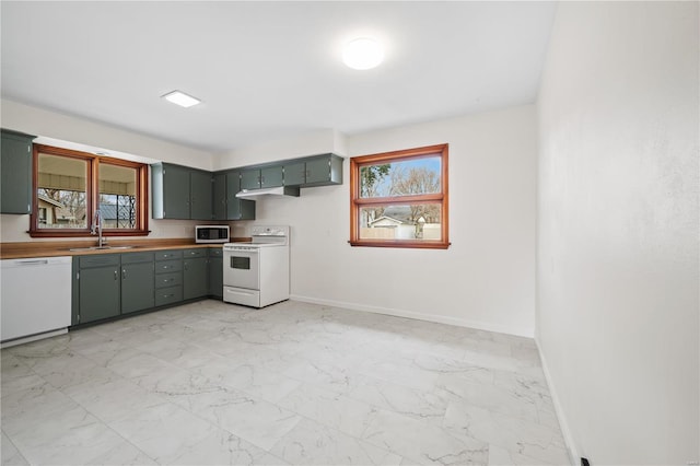 kitchen featuring white appliances, baseboards, marble finish floor, and a sink