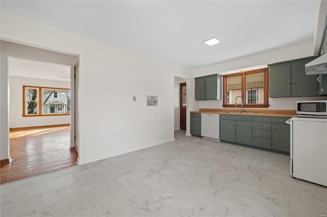 kitchen featuring marble finish floor, stainless steel microwave, and dishwasher