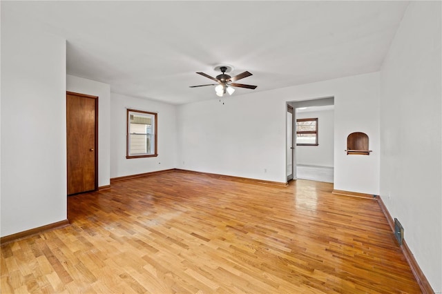 empty room with light wood finished floors, ceiling fan, and baseboards