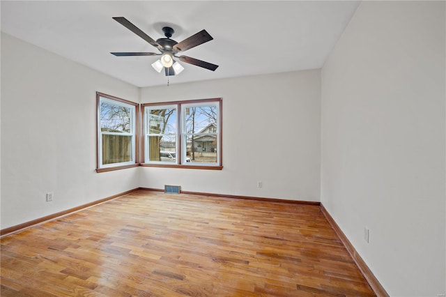 spare room with light wood finished floors, baseboards, and visible vents