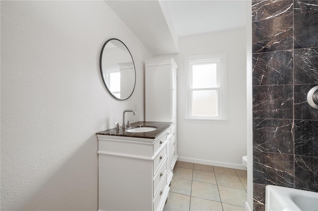 bathroom featuring a bathtub, tile patterned floors, vanity, baseboards, and walk in shower