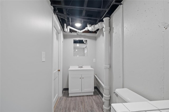 bathroom with vanity, toilet, and wood finished floors