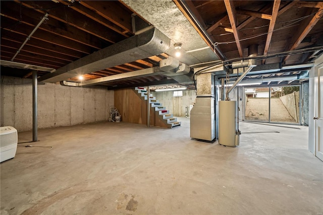 unfinished basement with water heater and stairway