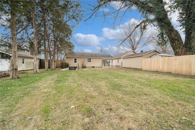 back of property featuring fence and a lawn