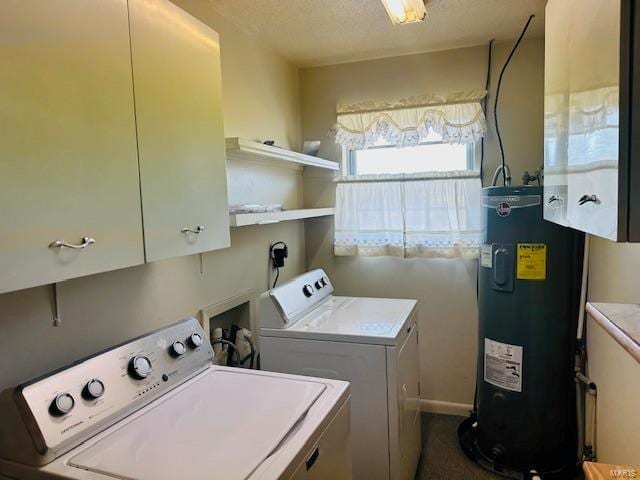 washroom featuring cabinet space, water heater, independent washer and dryer, and a textured ceiling