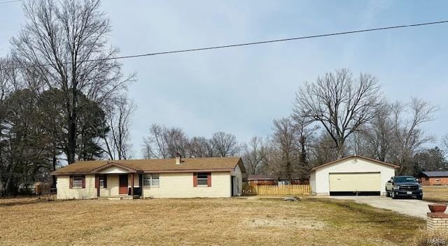 single story home featuring an outbuilding, a detached garage, and a front yard