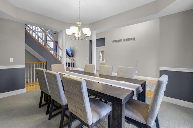 dining space featuring carpet, ornate columns, visible vents, an inviting chandelier, and baseboards