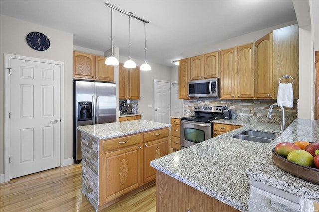 kitchen with light stone counters, a center island, a sink, stainless steel appliances, and backsplash