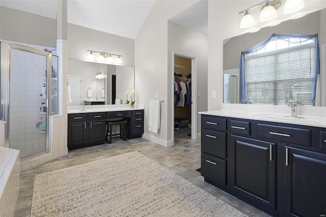 full bath with lofted ceiling, a stall shower, two vanities, and a sink