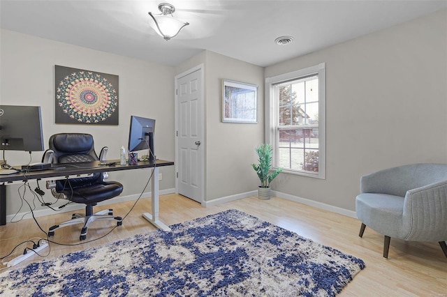 office area featuring visible vents, baseboards, and wood finished floors