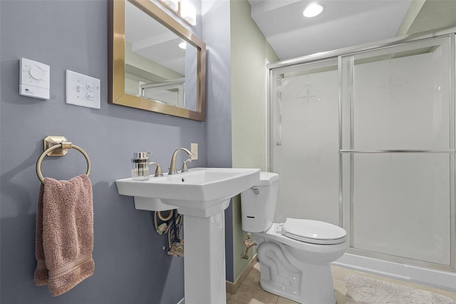 bathroom with toilet, a stall shower, and tile patterned floors