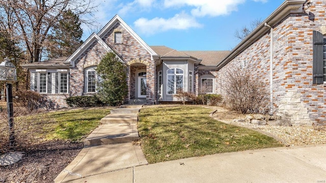 view of front of home featuring a front lawn and brick siding